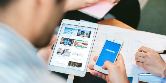 Mann hält iphone mit Coursera-Website auf iphone